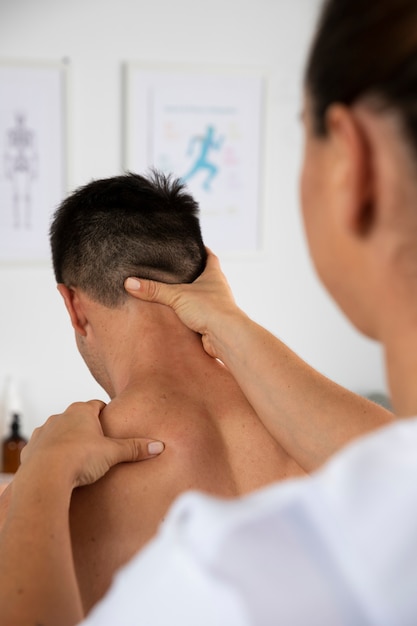 Physiotherapist performing therapeutic massage on male client