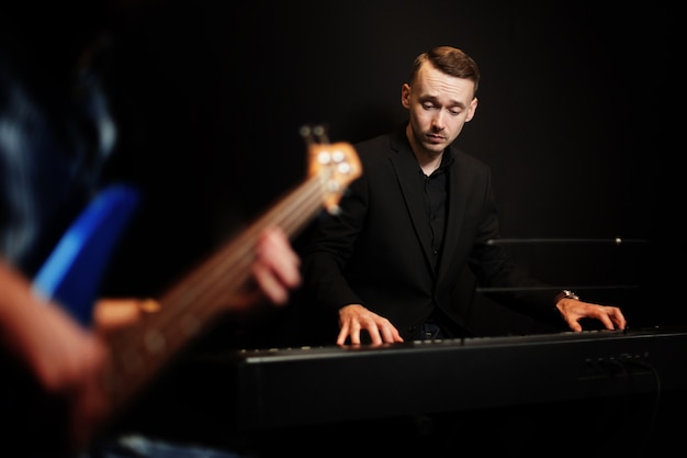 Free photo pianist with guitar in foreground