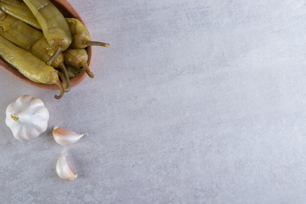 Pickled chili pepper placed on a stone background.