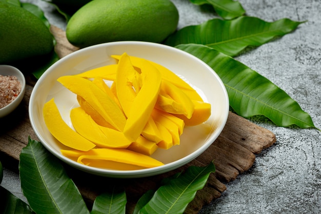 Pickled mango on dark wooden surface