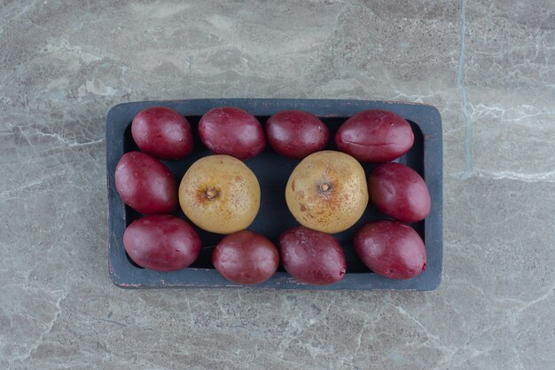 Pickled olives and apples on wooden plate