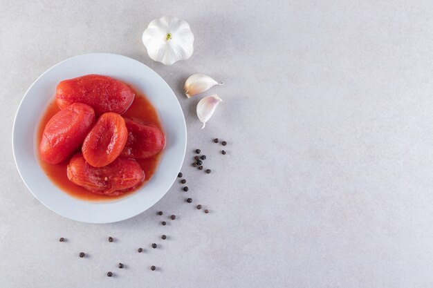 Pickled tomato vegetables with fresh garlic and pepper corns . 