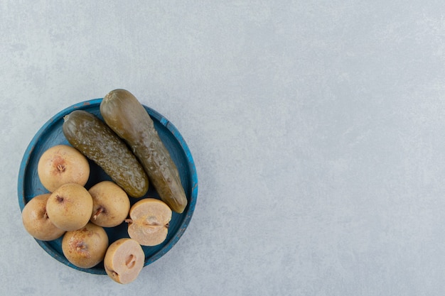 Free photo pickles cucumber and apples on wooden plate