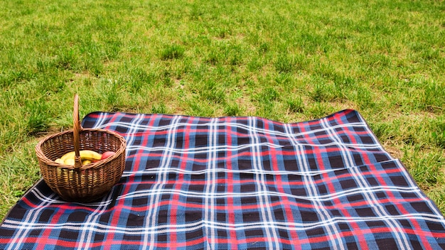 Free photo picnic basket on blanket over the green grass