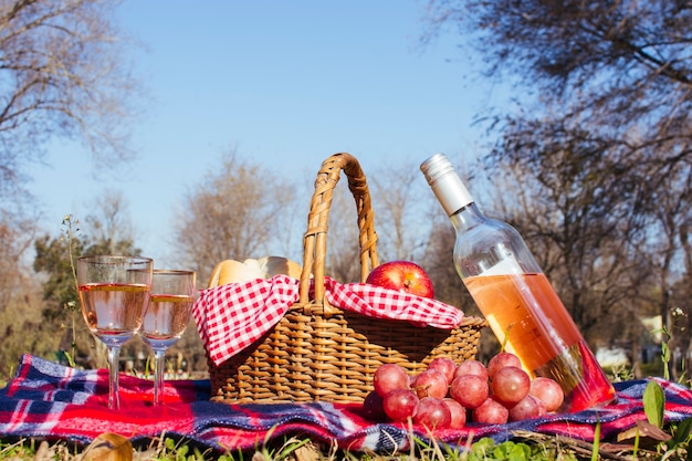 Free photo picnic basket with two glasses of white wine