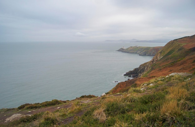 Free Photo picture of bay with green meadow and lighthouse in the background