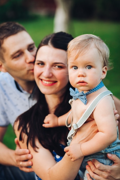 Picture of cheerful caucasian mum, dad and their child have fun together and smiles in the garden