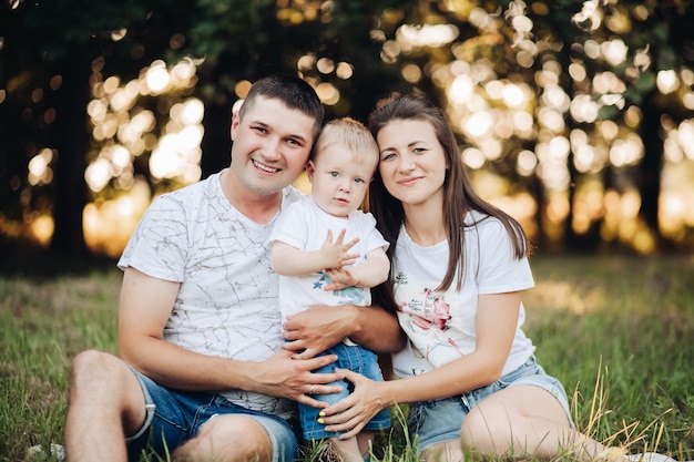 Picture of cheerful caucasian mum, dad and their child have fun together and smiles in the garden