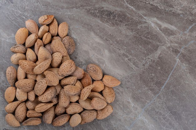 A picture of a heart made of almonds , on the marble surface