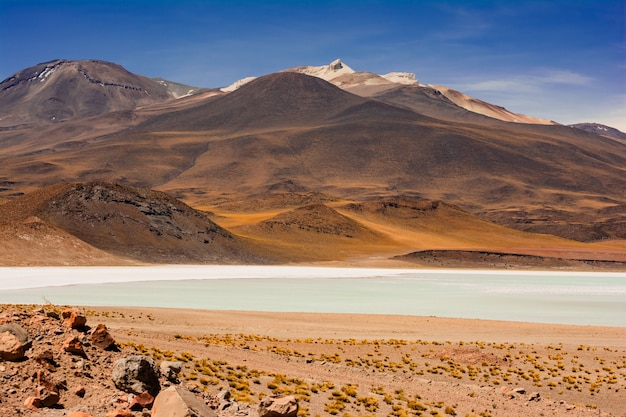 Free photo picture of a lake against mesmerizing brown mountains under the great sky