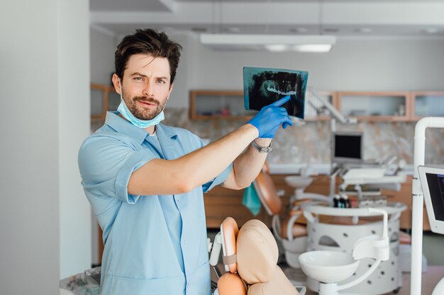 Picture of male doctor or dentist looking at x-ray, at his office.