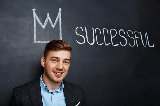 Free Photo picture of man over blackboard with crown and text successful