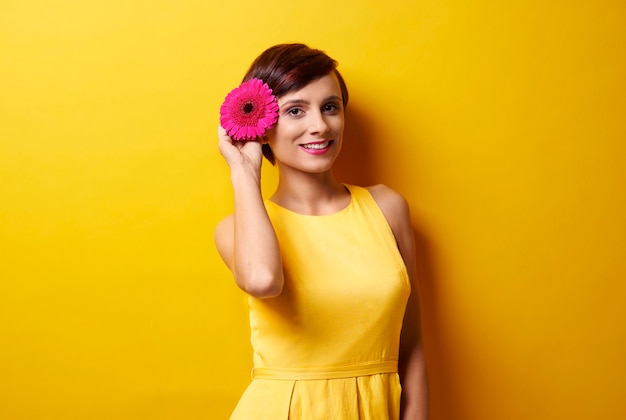 Picture of model holding flower next to ear