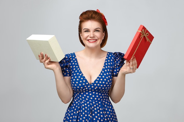 Free Photo picture of overjoyed excited young european female dressed in vintage outfit smiling happily, showing genuine true emotions, holding box with present, receiving long awaited gadget on birthday