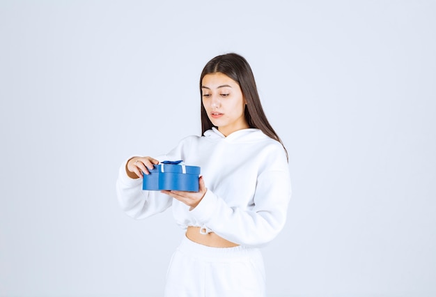 Picture of a pretty young girl model holding a heart shaped gift box.