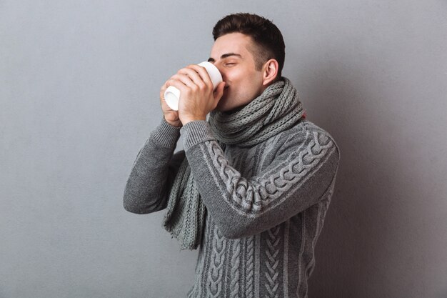 Picture of Sick Man in sweater and scarf drinking tea