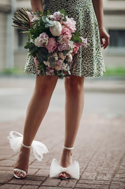 Picture of slim woman in green dress holding a boquet of flowers