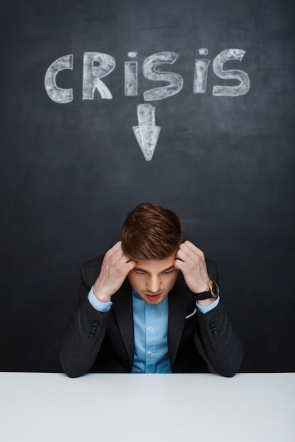 Free photo picture of tired man over blackboard with crisis inscription