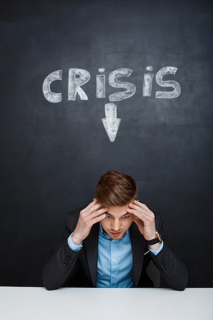 Free photo picture of tired man over blackboard with crisis inscription