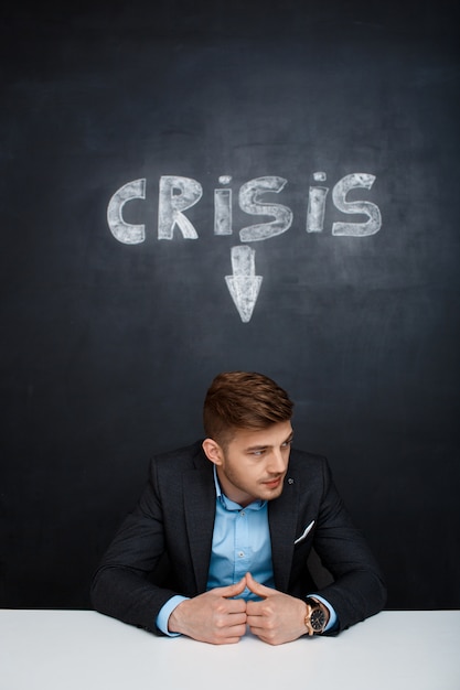 Free photo picture of tired man over blackboard with crisis inscription