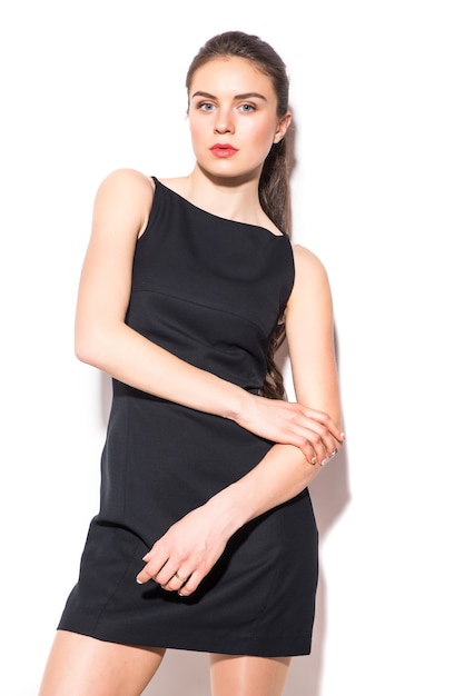 Free photo a picture of a young beautiful woman in a black dress posing over white background