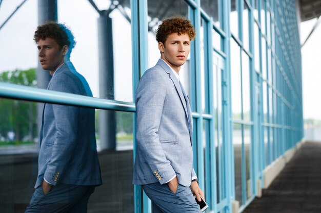 Picture of young confident redhaired businessman in the street