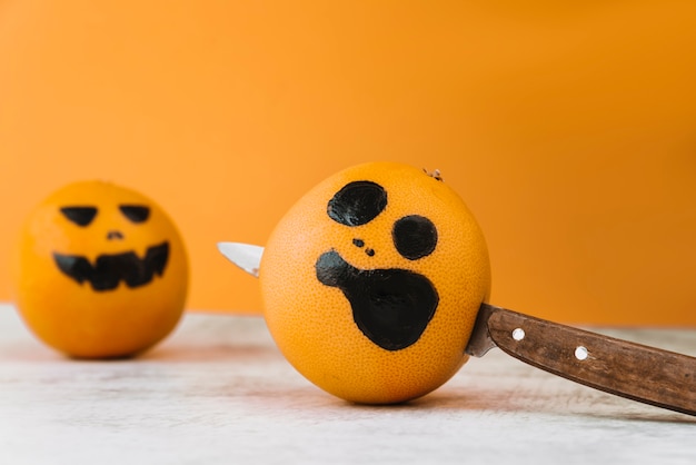 Free photo pictured citrus with knife within and another orange on background