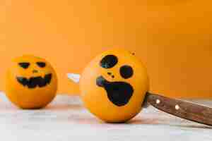 Free photo pictured citrus with knife within and another orange on background