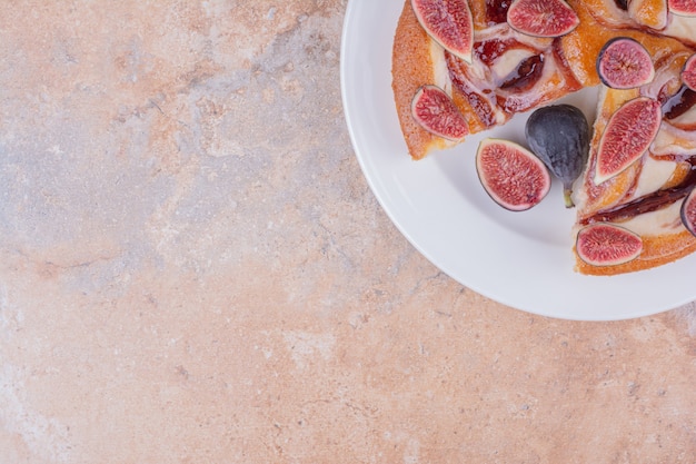 Free Photo pie with figs and chocolate syrup in a white plate.