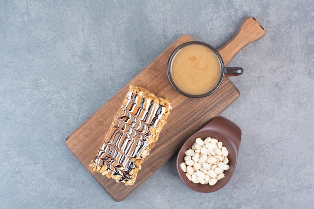 A piece of cake with cup of aroma coffee on gray surface 