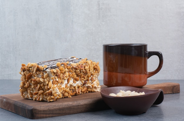 A piece of cake with cup of aroma coffee on gray table .