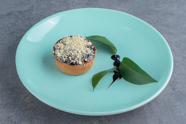 A piece of creamy cake with leaves on a green plate