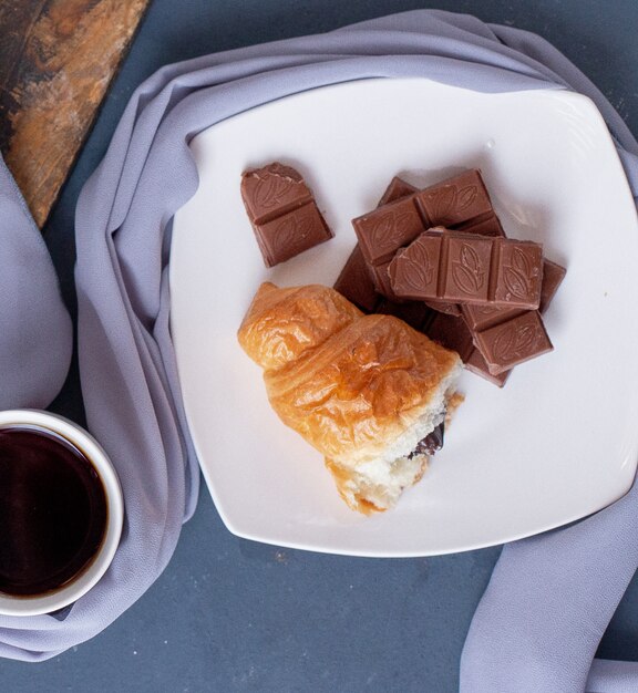 piece of croissant and chocolate bar in a white plate