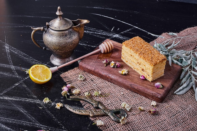 A piece of honey cake with dried flowers on marble table. 