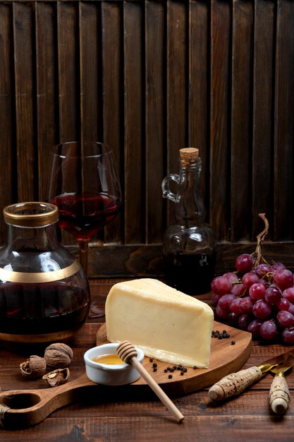 Piece of parmesan cheese served with grape and wine