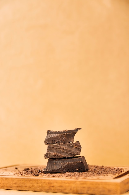 Pieces of chocolate and chocolate curls on cutting board