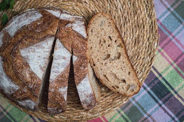 Free photo pieces of fresh homemade sourdough bread slicing artisan bread on a straw lining top view