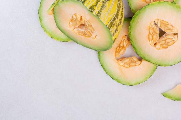 Pieces of green melon on white surface