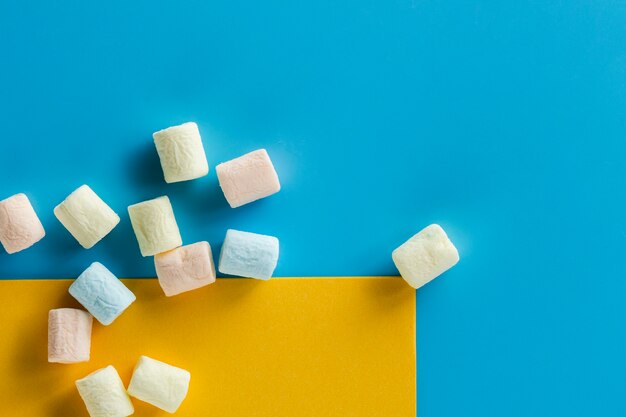 Pieces of marshmallow on blue surface