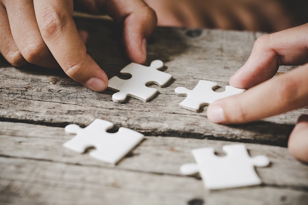 pieces of white jigsaw on wood