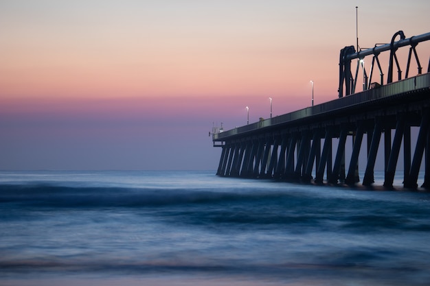 Pier near the calm sea under the beautiful sunset sky