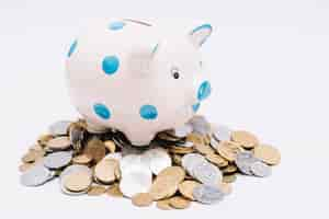 Free photo piggybank over many coins on white background