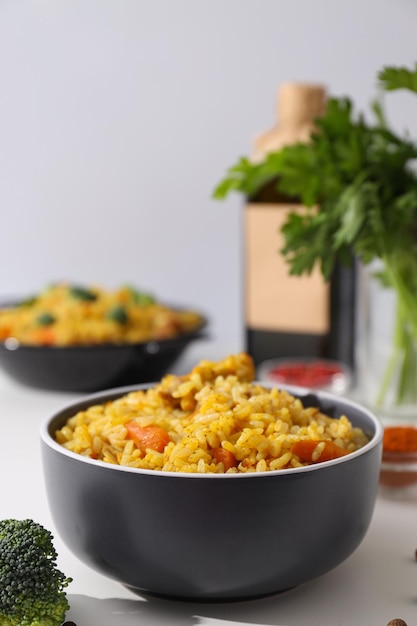 Free photo pilaf in bowls spices and bottle on white background close up