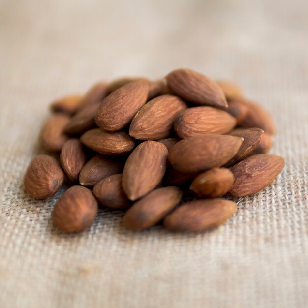 Pile of almonds on beige fabric