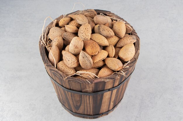 A pile of almonds in the bucket, on the marble surface