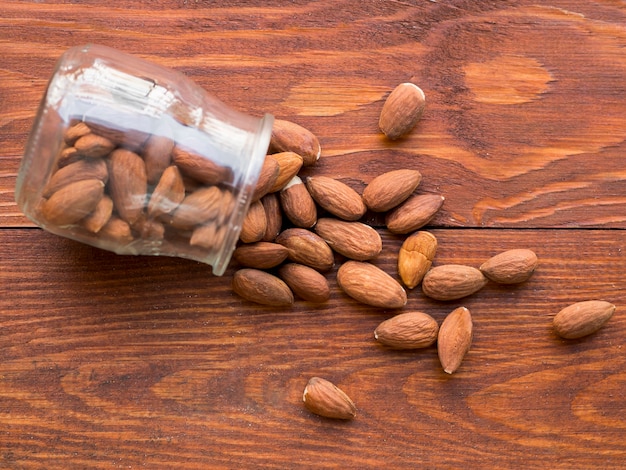 Free photo pile of almonds inside a fallen jar