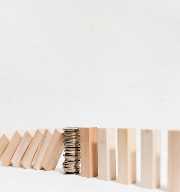 Pile of coins stopping fallen wooden pieces