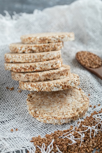 Pile of crispbread and raw buckwheat on white burlap