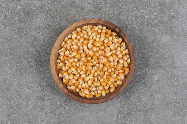 Pile of dried corns in wooden bowl.