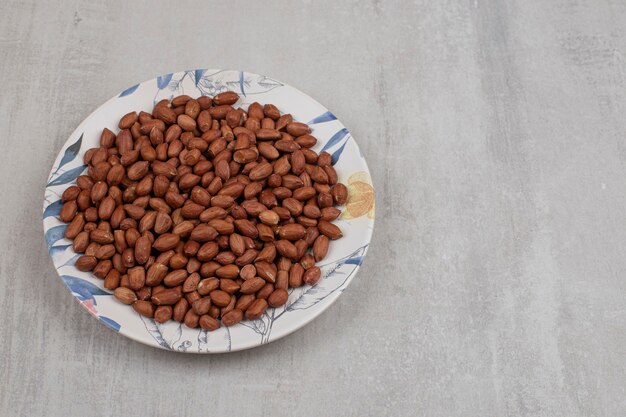 Pile of fresh peanuts on colorful plate.